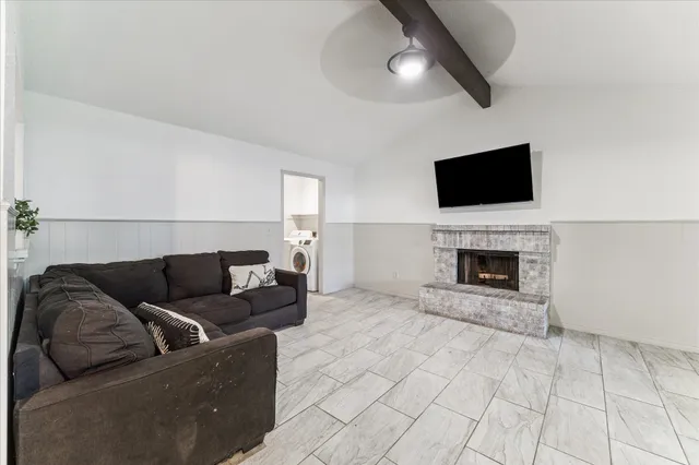 a living room with furniture a flat screen tv and a fireplace