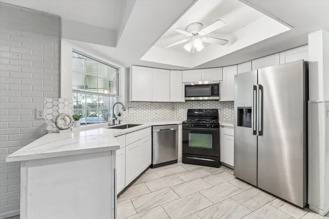 a kitchen with stainless steel appliances granite countertop a sink refrigerator stove and microwave