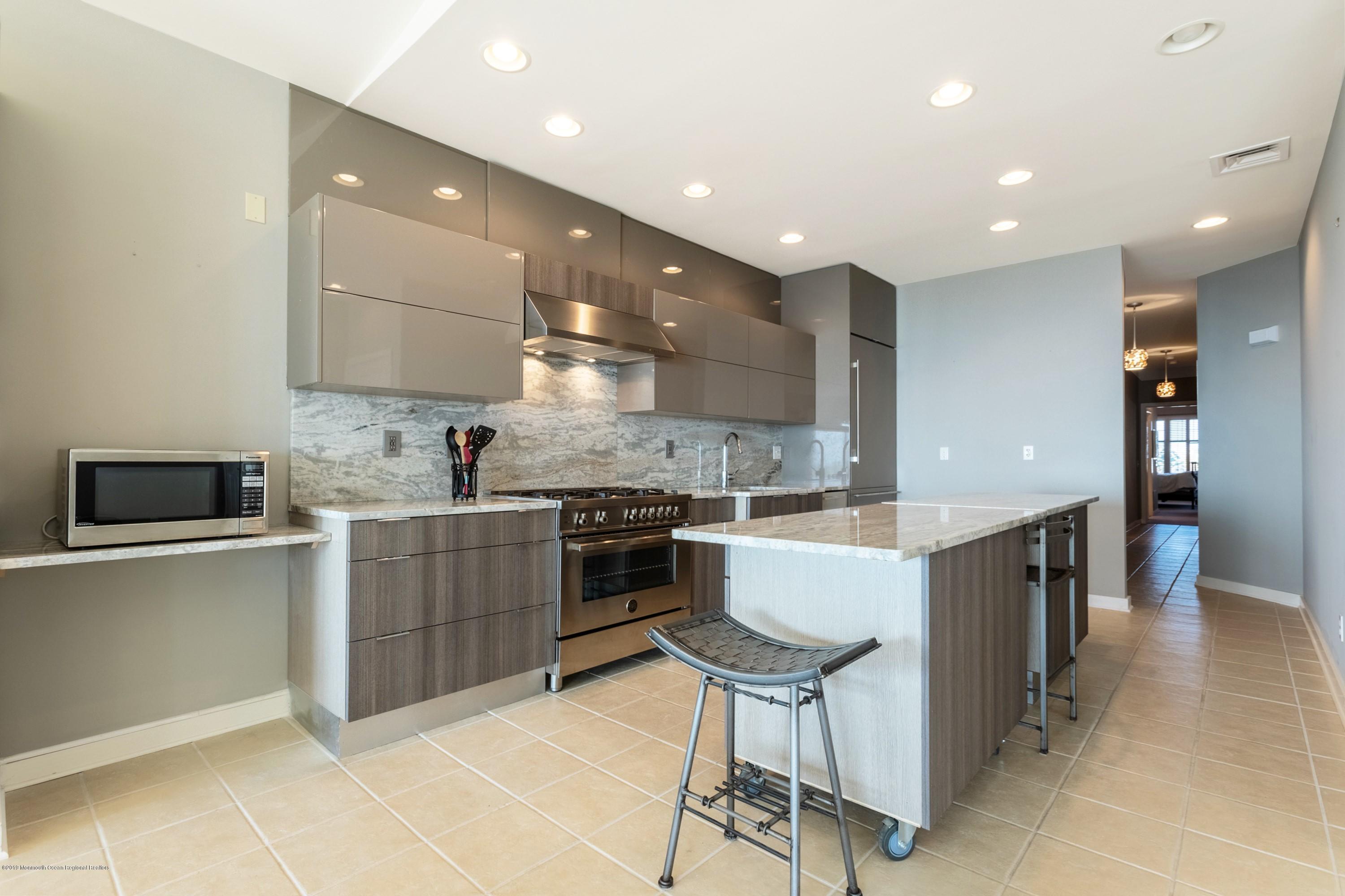 239 Beach Front, Unit 4 Manasquan, NJ 08736 - Photo 6 of 14 a large kitchen with a large counter top space a sink stainless steel appliances and cabinets