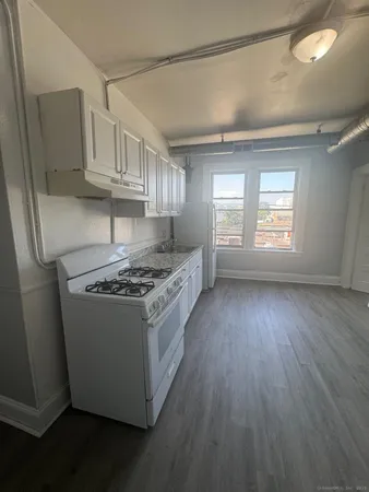a kitchen with granite countertop a sink dishwasher a stove and a refrigerator