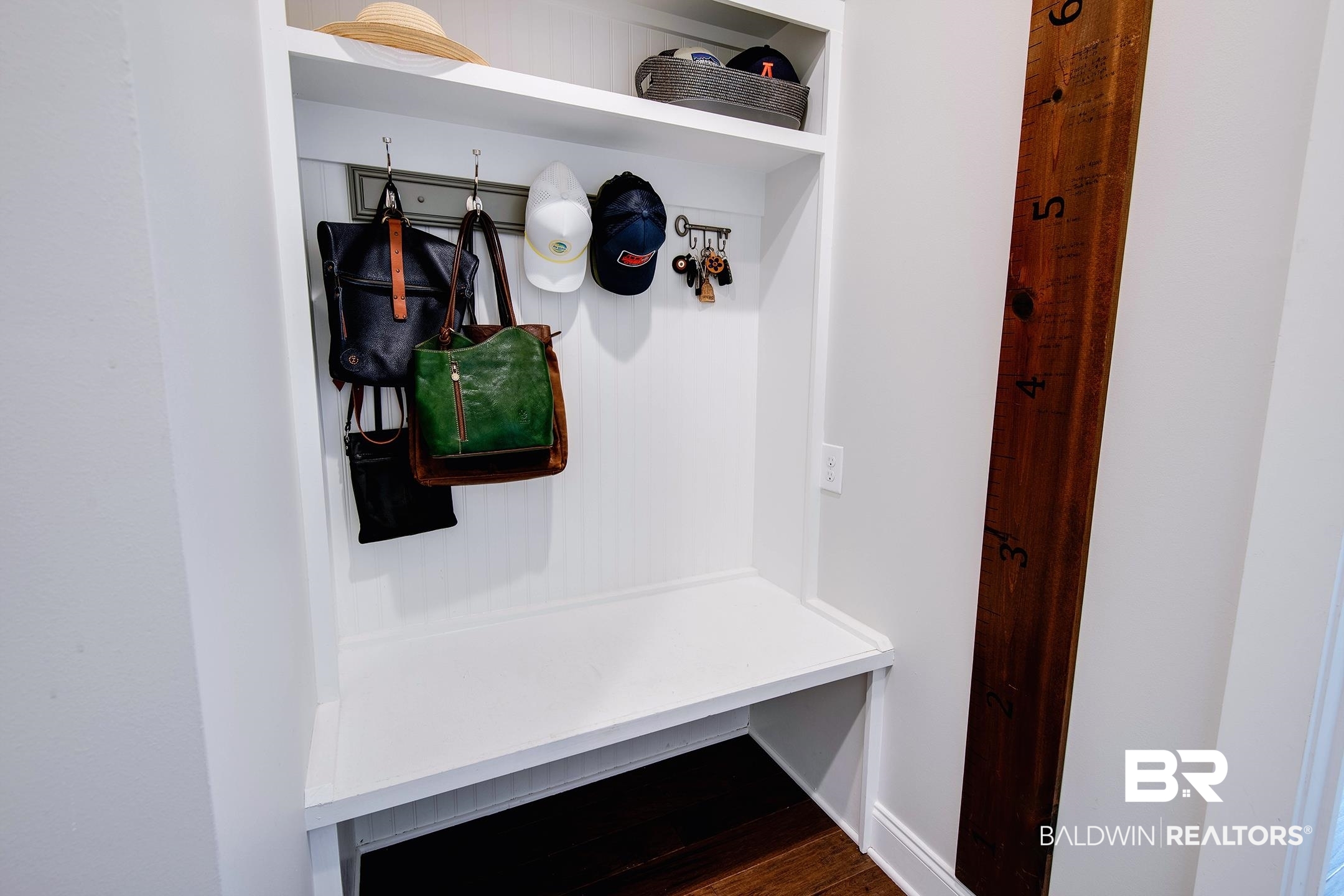 18754 Treasure Oaks Road Gulf Shores, AL 36542 - Photo 33 of 53 Built-in mudroom bench with white cabinetry, upper shelving, and a coat rack with hooks