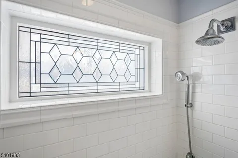 a bathroom with a window and a shower