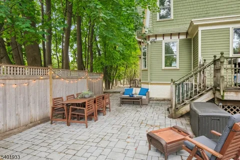 a view of a patio with table and chairs and wooden fence