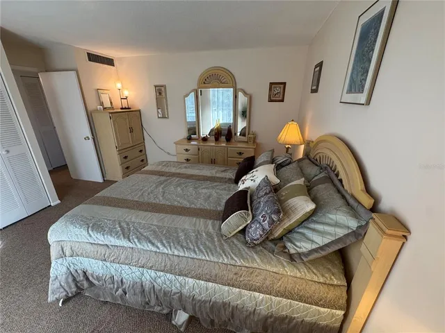 a bedroom with a bed and large windows