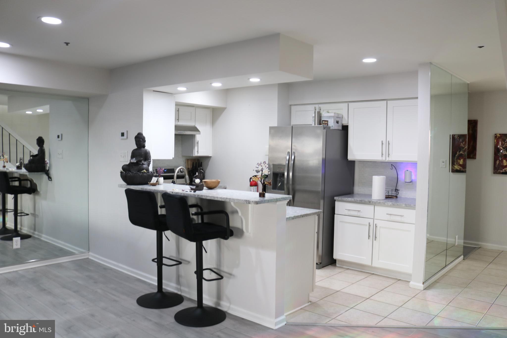 1031 Main Street Voorhees, NJ 08043 - Photo 12 of 32 a kitchen with stainless steel appliances kitchen island granite countertop a refrigerator a sink dishwasher and a dining table with wooden floor