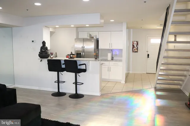 a kitchen with stainless steel appliances kitchen island granite countertop a table and chairs in it