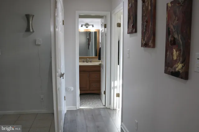 a view of a hallway with closet and a bathroom