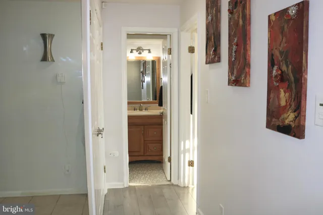 a view of a hallway with bathroom and front door