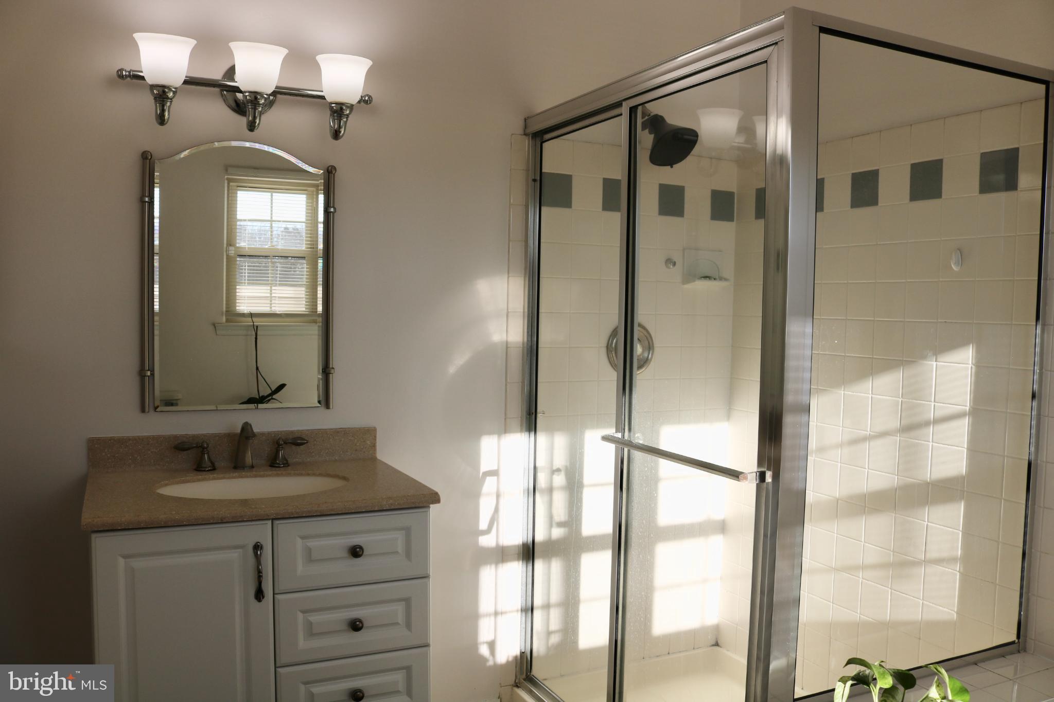 1031 Main Street Voorhees, NJ 08043 - Photo 5 of 32 a bathroom with a shower sink and mirror