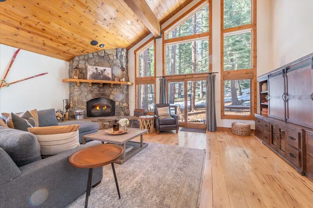a living room with furniture a fireplace and a floor to ceiling window