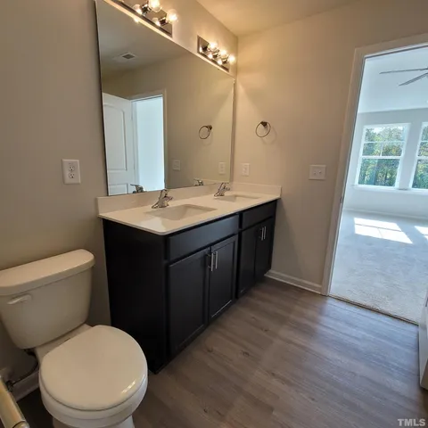 a bathroom with a granite countertop toilet sink and mirror