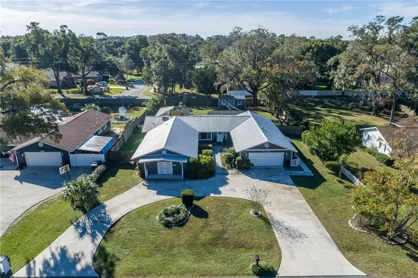 an aerial view of a house with garden space and trees