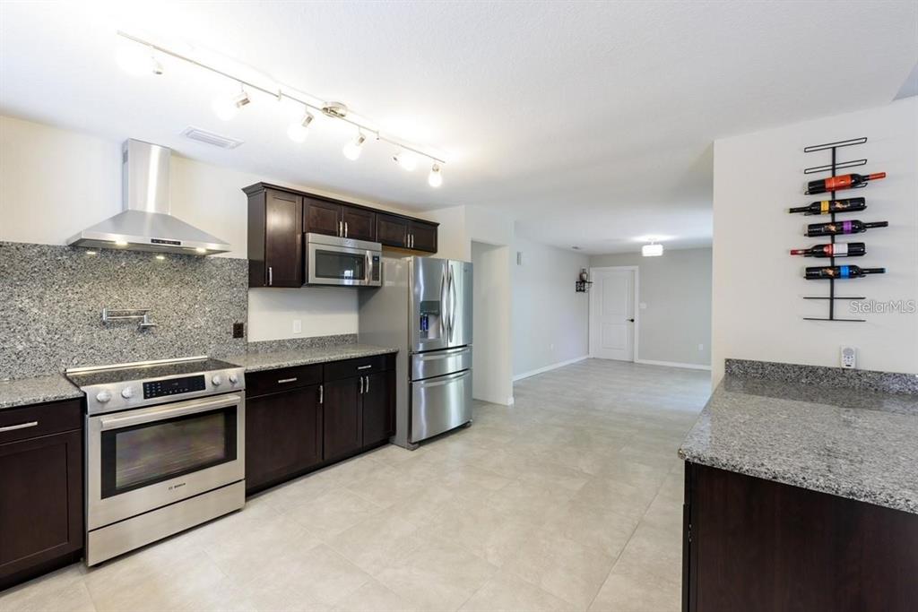 5002 Southeast 7th Place Ocala, FL 34471 - Photo 11 of 30 a kitchen with stainless steel appliances granite countertop a sink stove and refrigerator