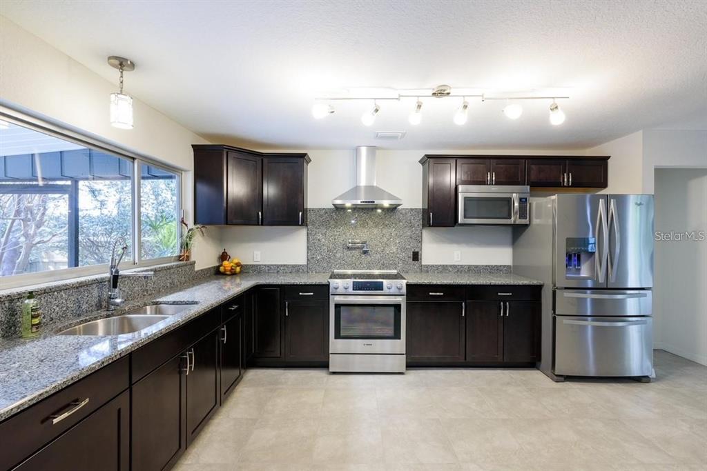 5002 Southeast 7th Place Ocala, FL 34471 - Photo 12 of 30 a kitchen with stainless steel appliances granite countertop a sink a stove and cabinets