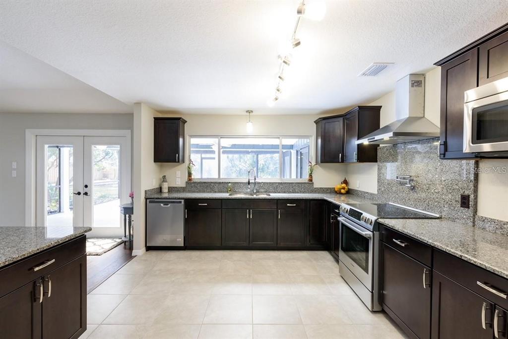 5002 Southeast 7th Place Ocala, FL 34471 - Photo 13 of 30 a large kitchen with stainless steel appliances granite countertop a sink stove and refrigerator