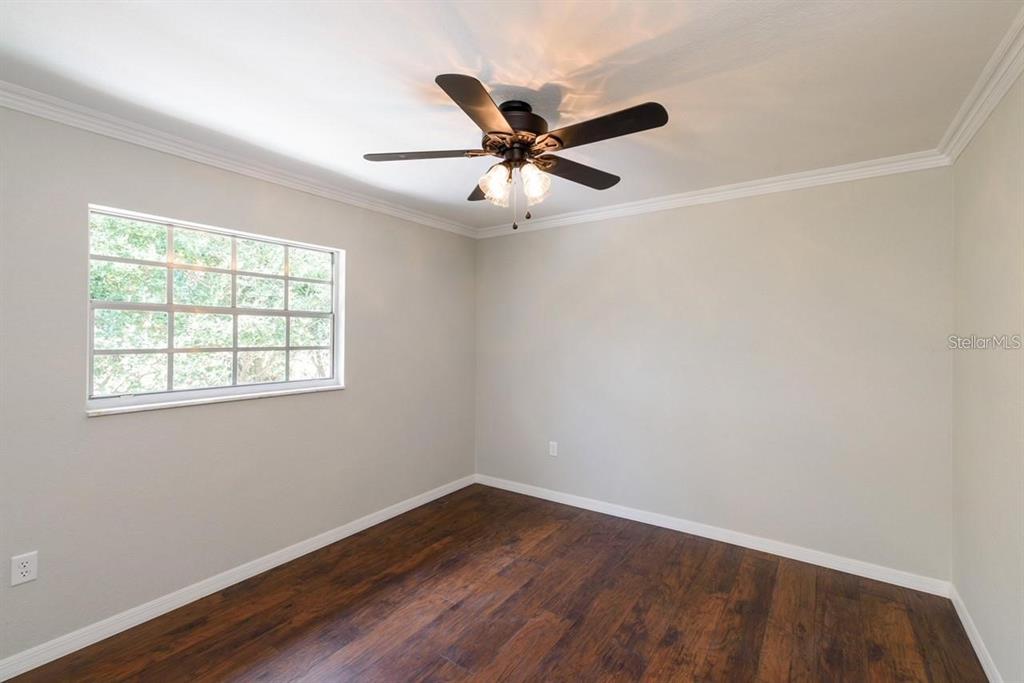 5002 Southeast 7th Place Ocala, FL 34471 - Photo 26 of 30 an empty room with wooden floor fan and windows