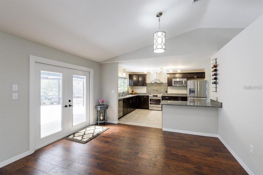 5002 Southeast 7th Place Ocala, FL 34471 - Photo 8 of 30 a view of a kitchen with furniture a refrigerator and wooden floor