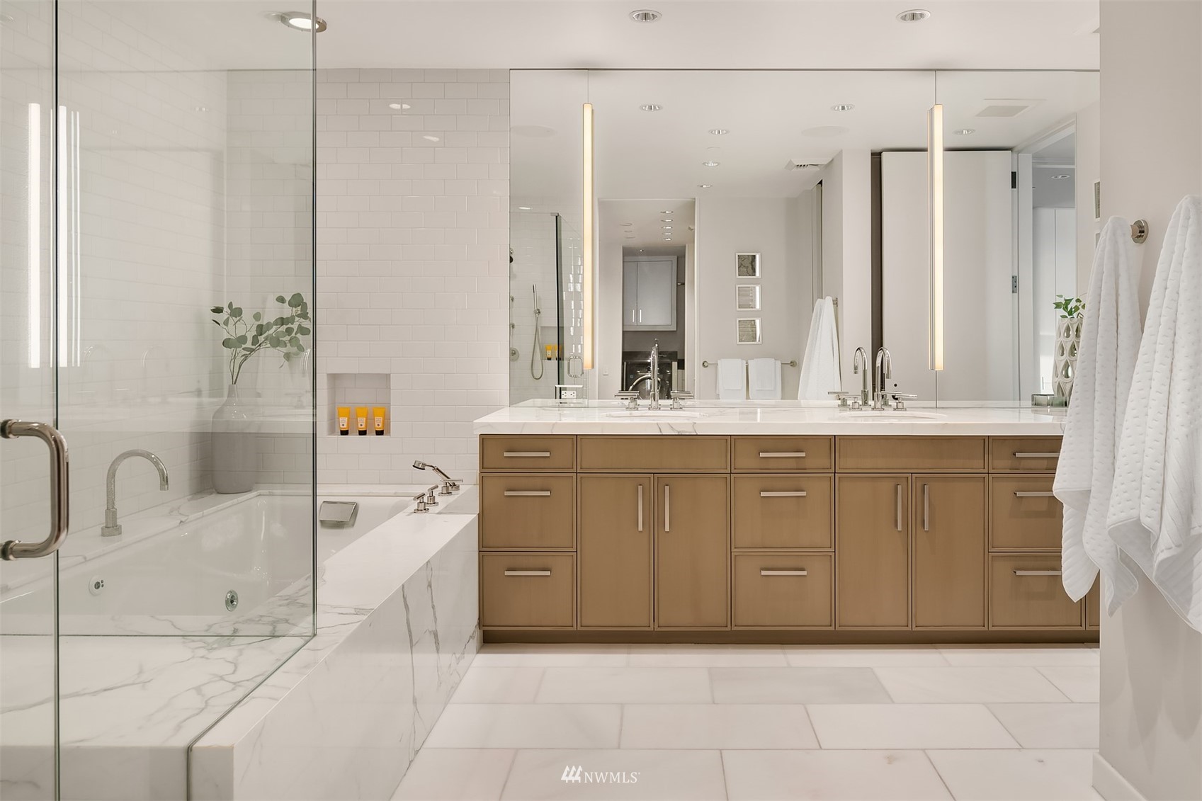 715 2nd Avenue, Unit 1702 Seattle, WA 98104 - Photo 17 of 26 a bathroom with a double vanity sink a mirror and a bathtub