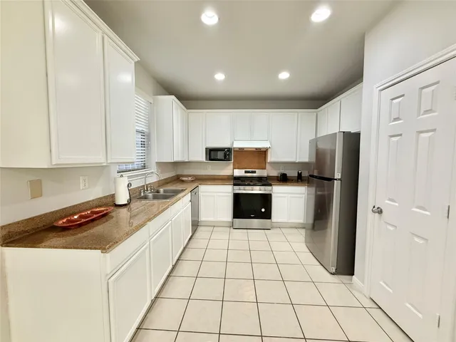 a kitchen with stainless steel appliances a refrigerator sink and cabinets