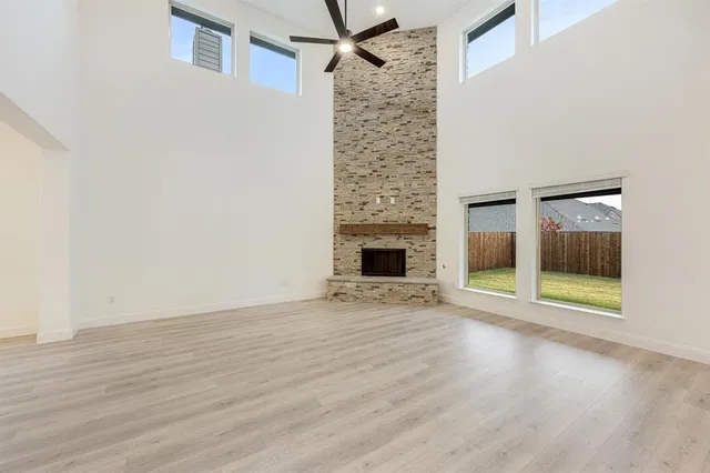 a view of an empty room with wooden floor and a fireplace