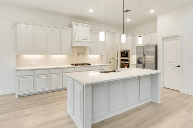 a kitchen with kitchen island white cabinets and white appliances