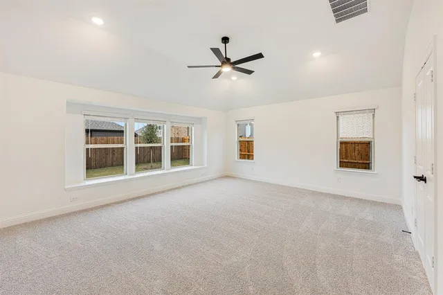 a view of an empty room with a window and a ceiling fan
