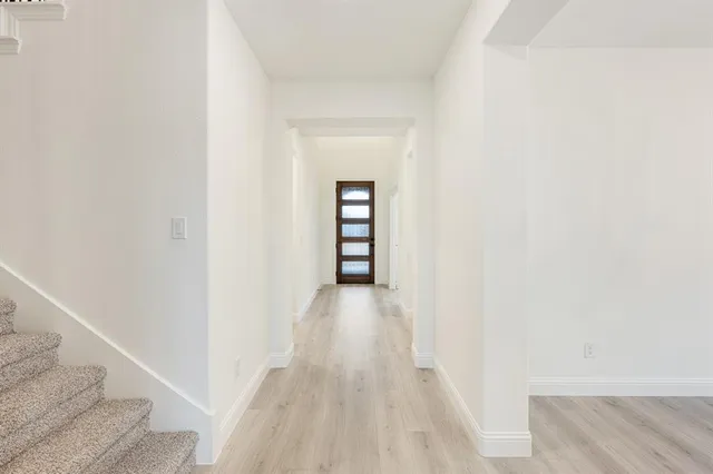a view of a hallway with wooden floor and staircase