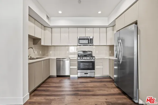 a kitchen with white cabinets and stainless steel appliances