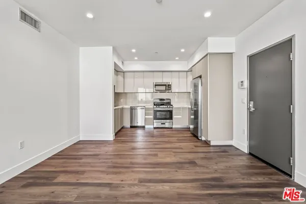 a view of kitchen refrigerator and wooden floor