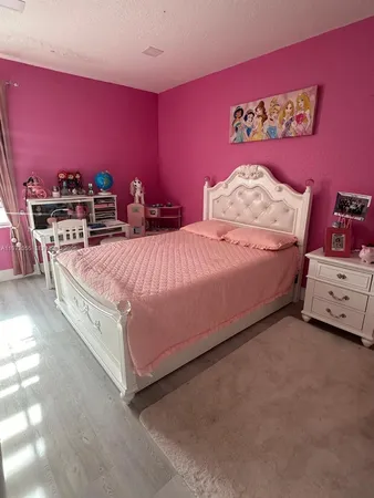a spacious bedroom with a bed and a view of living room