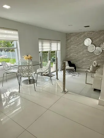 a dining room with furniture and a large window