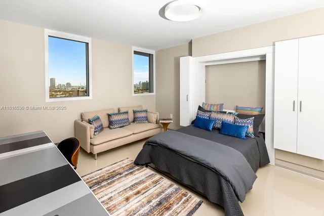 a bedroom with a bed couch and a window