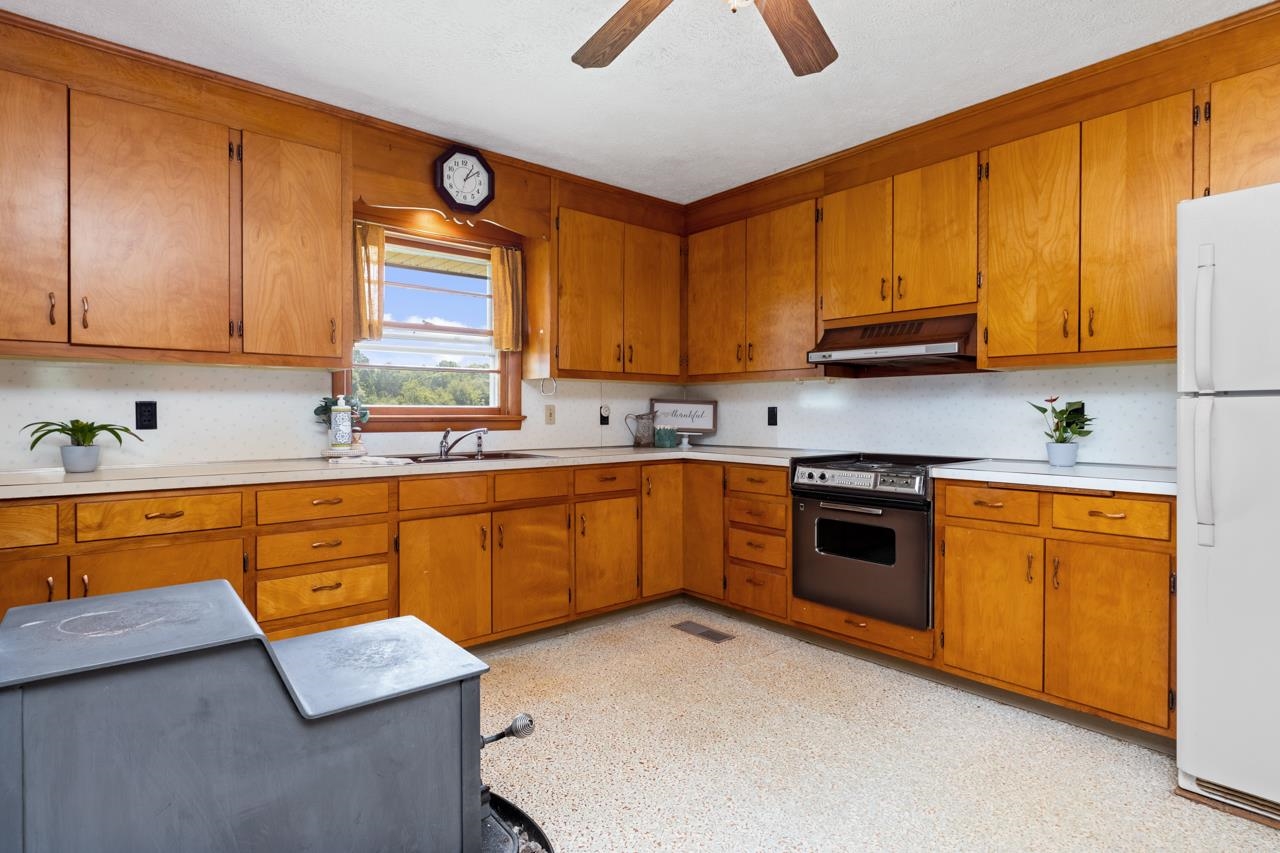 3252 Lyndhurst Road Stuarts Draft, VA 24477 - Photo 3 of 75 a kitchen with stainless steel appliances granite countertop wooden cabinets a sink a stove a dining table and chairs with wooden floor