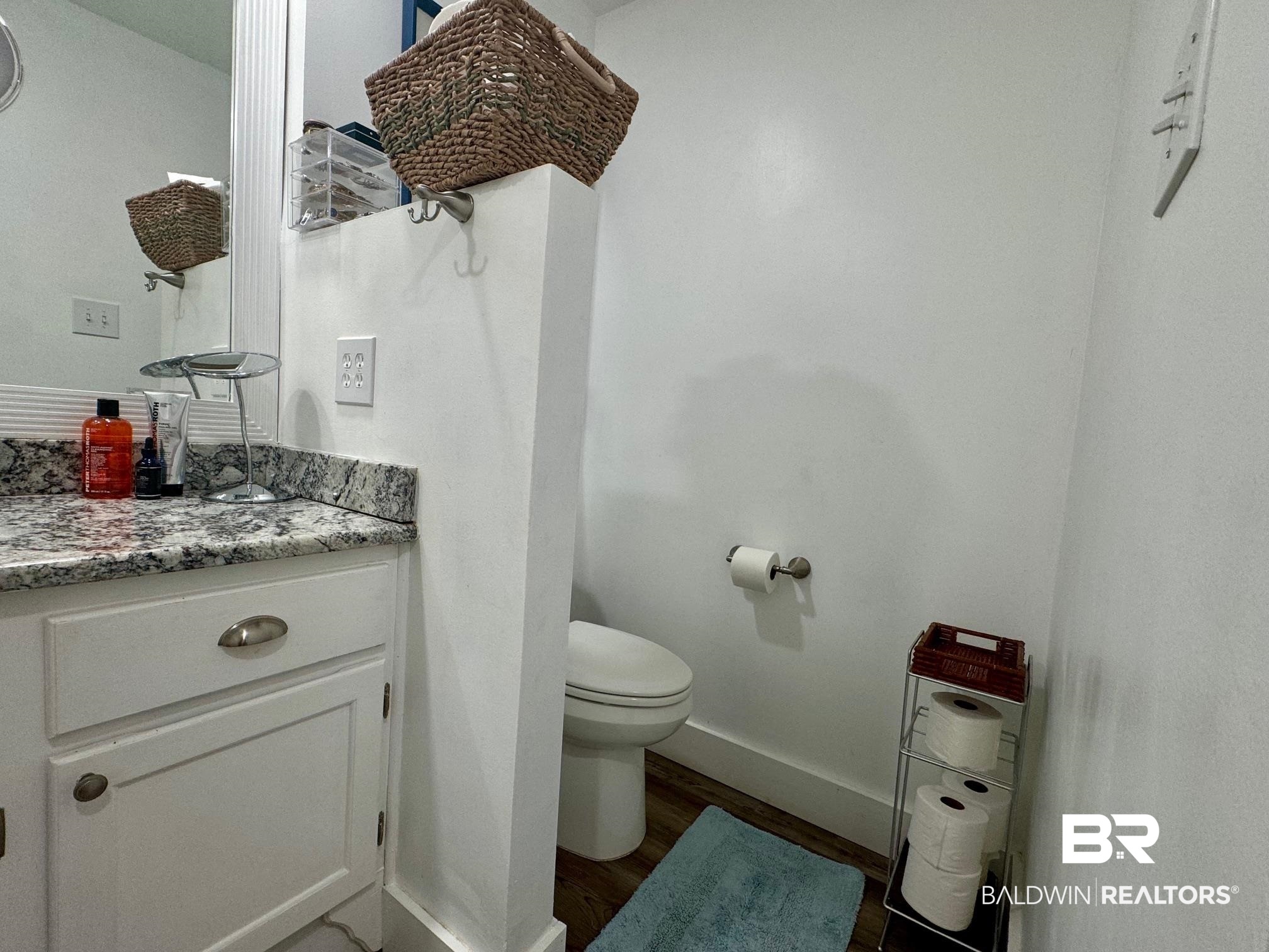 3200 Loop Road, Unit 55 Orange Beach, AL 36561 - Photo 20 of 40 Bathroom featuring vanity, toilet, and hardwood / wood-style flooring
