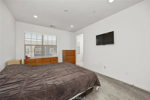 a bedroom with a bed and a flat tv screen
