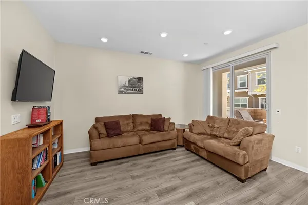 a kitchen with stainless steel appliances granite countertop a refrigerator a stove a sink dishwasher a dining table and chairs with wooden floor