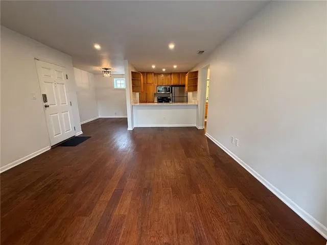a view of a big room with wooden floor and windows
