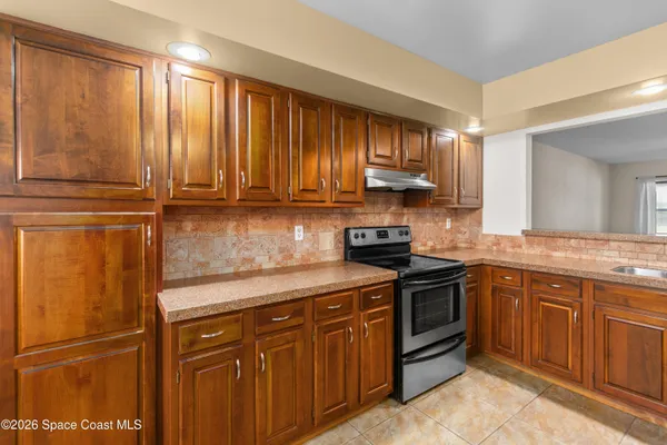 a kitchen with granite countertop a sink stove and cabinets