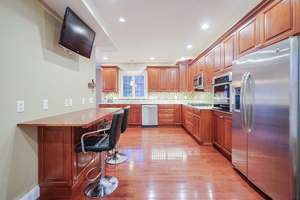 11 Hockanum Way Worcester, MA 01606 - Photo 6 of 36 a kitchen with stainless steel appliances kitchen island granite countertop a refrigerator a stove a sink dishwasher and a microwave with wooden floor