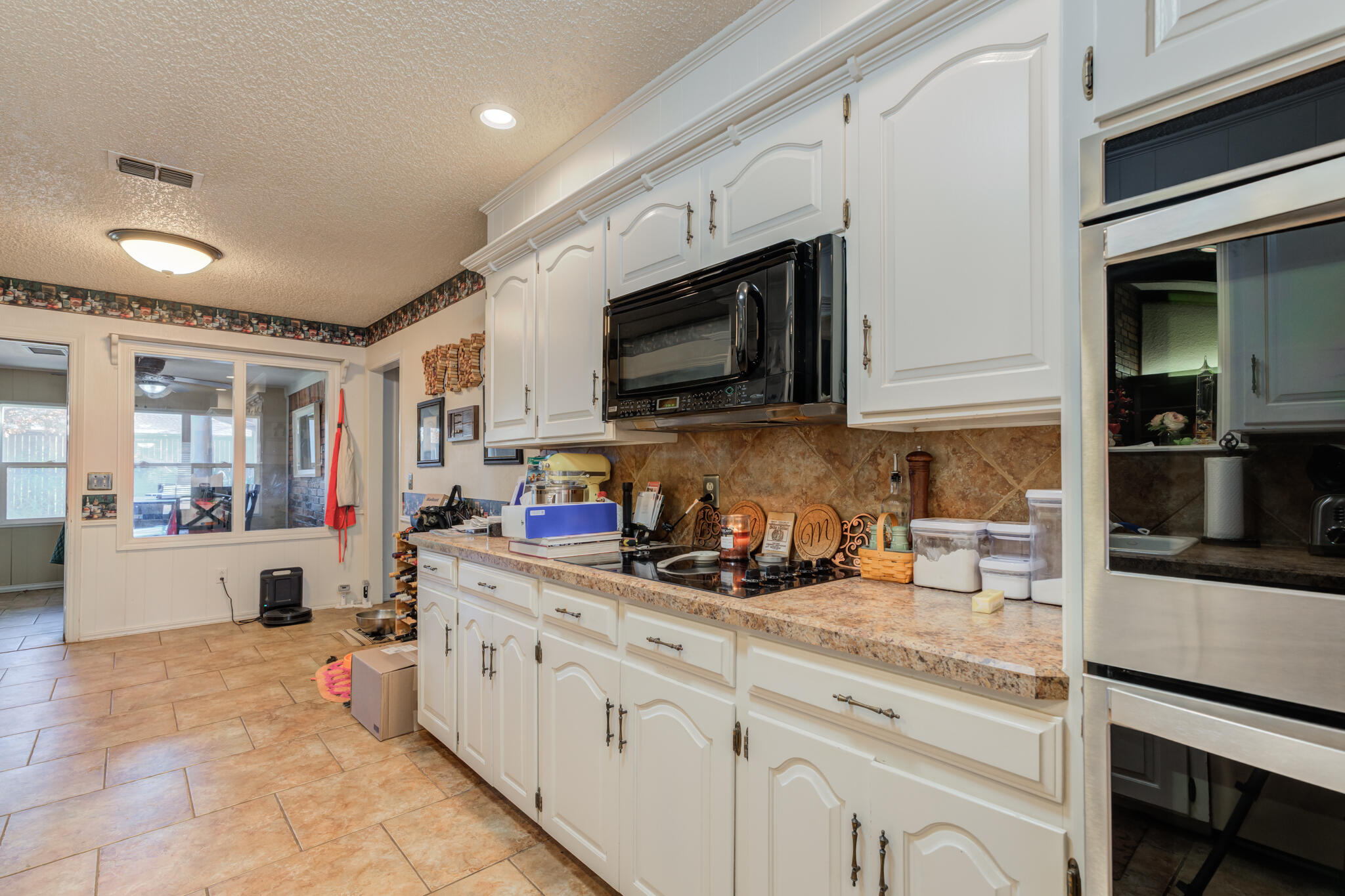 5713 76th Street Lubbock, TX 79424 - Photo 14 of 62 a kitchen with stainless steel appliances granite countertop a stove and cabinets