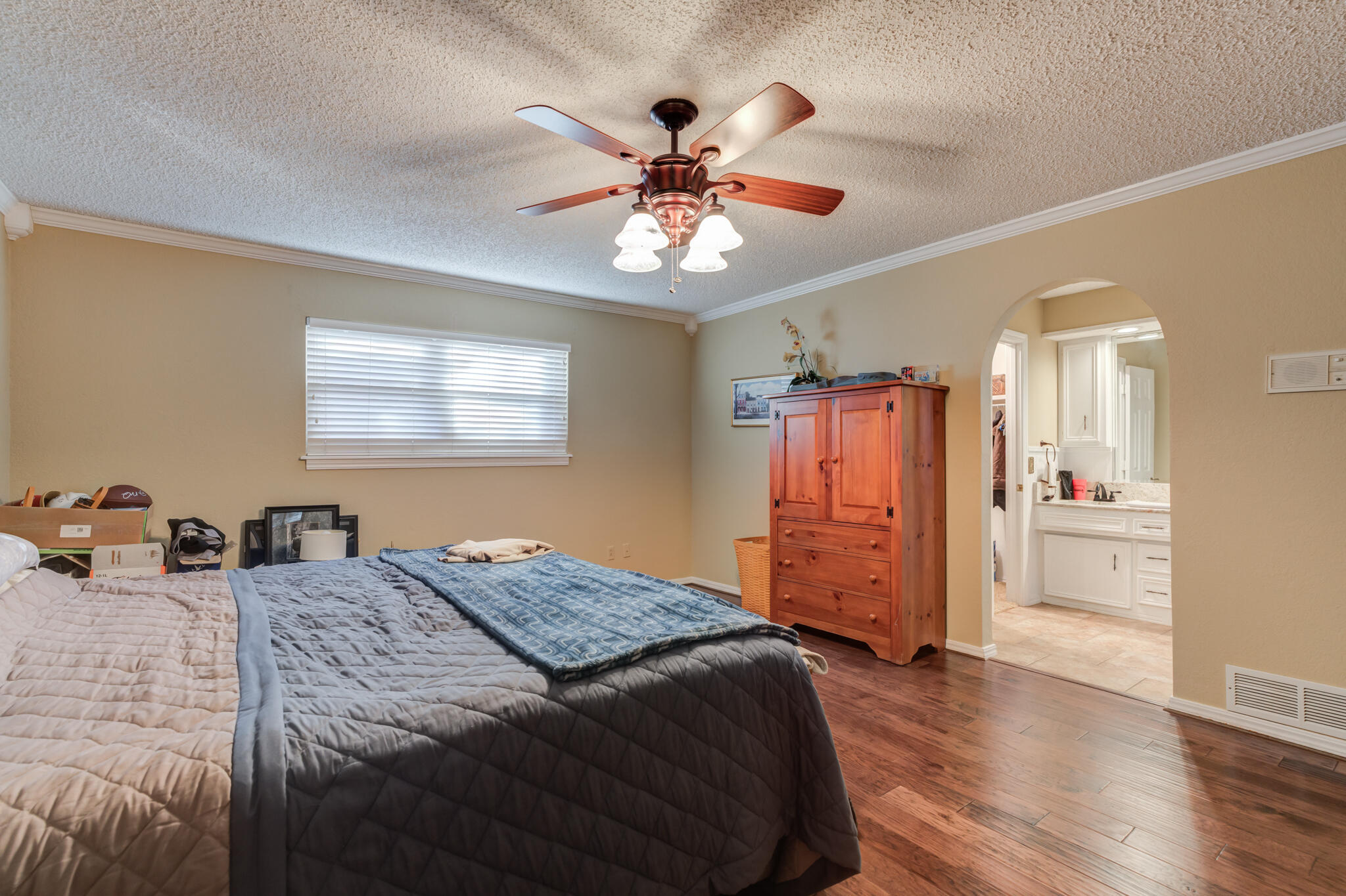 5713 76th Street Lubbock, TX 79424 - Photo 26 of 62 a bed room with a bed and a chandelier