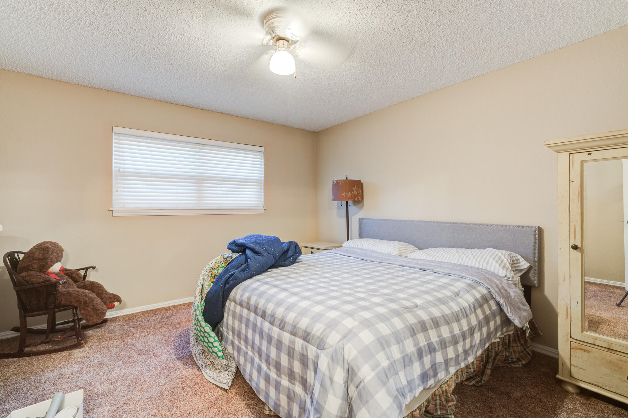 5713 76th Street Lubbock, TX 79424 - Photo 34 of 62 a bedroom with two beds and a chandelier