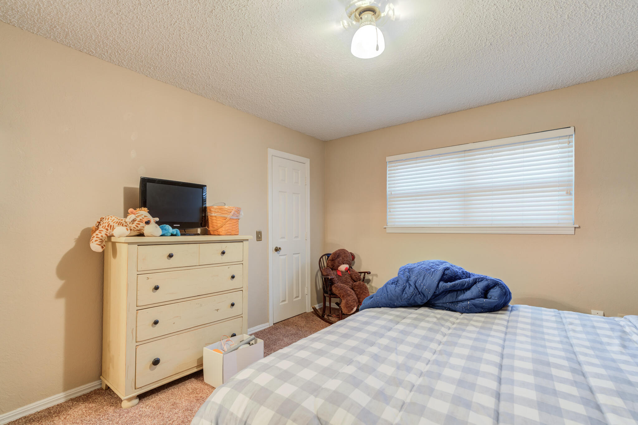 5713 76th Street Lubbock, TX 79424 - Photo 35 of 62 a bedroom with a bed and a flat screen tv