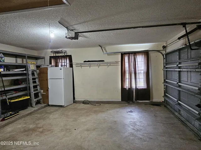 an empty room with a ceiling fan and a window