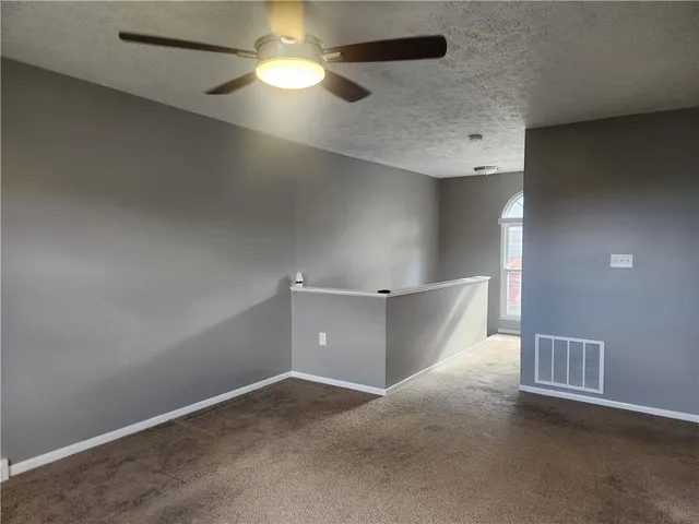 an empty room and chandelier fan