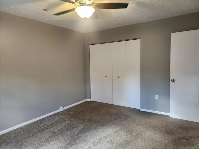 an empty room with a chandelier fan