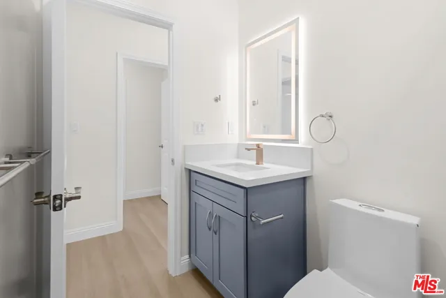 a bathroom with a sink mirror vanity and toilet