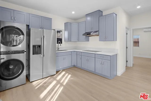 a kitchen with a refrigerator sink and cabinets