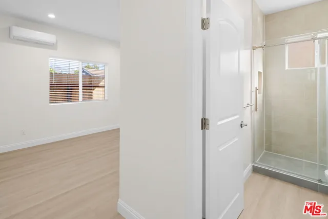 a view of bathroom with a shower and closet