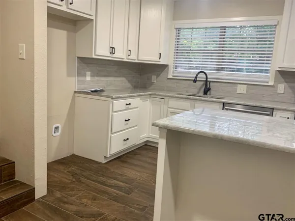 a kitchen with stainless steel appliances granite countertop a sink and a stove
